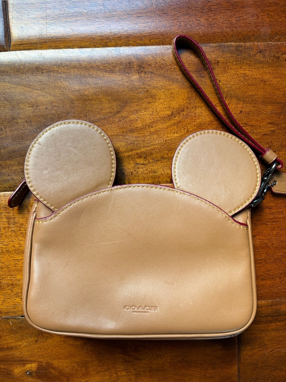 Limited Edition Disney x Coach Tan Leather Wristlet with Mickey Ear details.